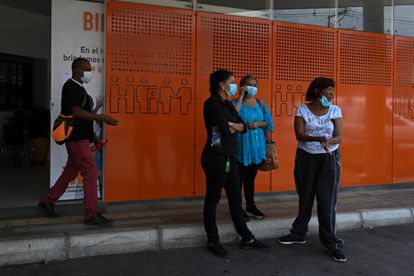 Un grupo de personas espera frente a un hospital en Medellín, Colombia.