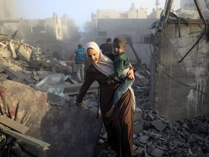 Una mujer huye con un niño durante un ataque aéreo en el campo de refugiados de al-Maghazi, en el centro de la franja de Gaza.