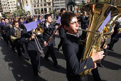 Los componentes de una banda de música, en un desfile festivo por las calles de Valencia.