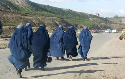 Un grupo de mujeres afganas vestidas con burkas caminan por las afueras de Kabul, Afganistán.
