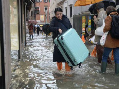 Turistas caminan por las calles inundadas de Venecia este viernes.