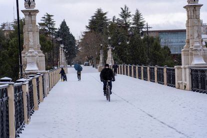 Un hombre pasea con su bicicleta por las calles nevadas de Teruel este sábado. La capital aragonesa registra unas máximas de 4 grados y unas mínimas de -7.