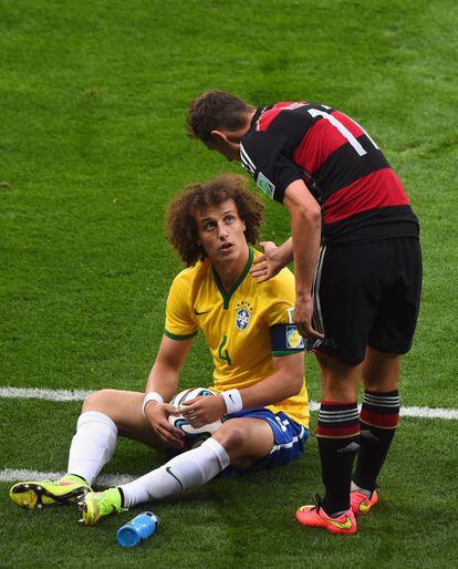 El jugador brasileño David Luiz (i) conversa con el jugador alemán Miroslav Klose después de una entrada.