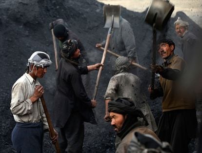 Trabajadores lanzan carbón en un camión a las afueras de Kabul (Afganistán).