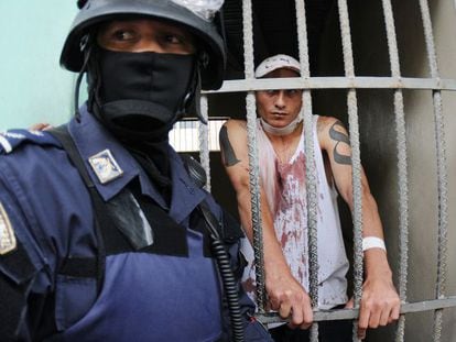 Un polic&iacute;a custodia a un preso herido en una prisi&oacute;n de Tegucigalpa.