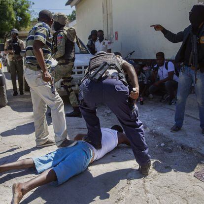Uno de los fugados es sometido por un policía, en Puerto Príncipe. 