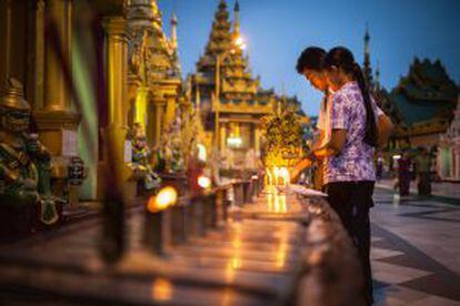 Encendiendo velas en la pagoda de Shwedagon, en Yangón (Myanmar).