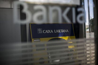 Un caixer que encara manté la marca de Caixa Laietana sobreviu inservible dins d'un recinte de Bankia tancat.