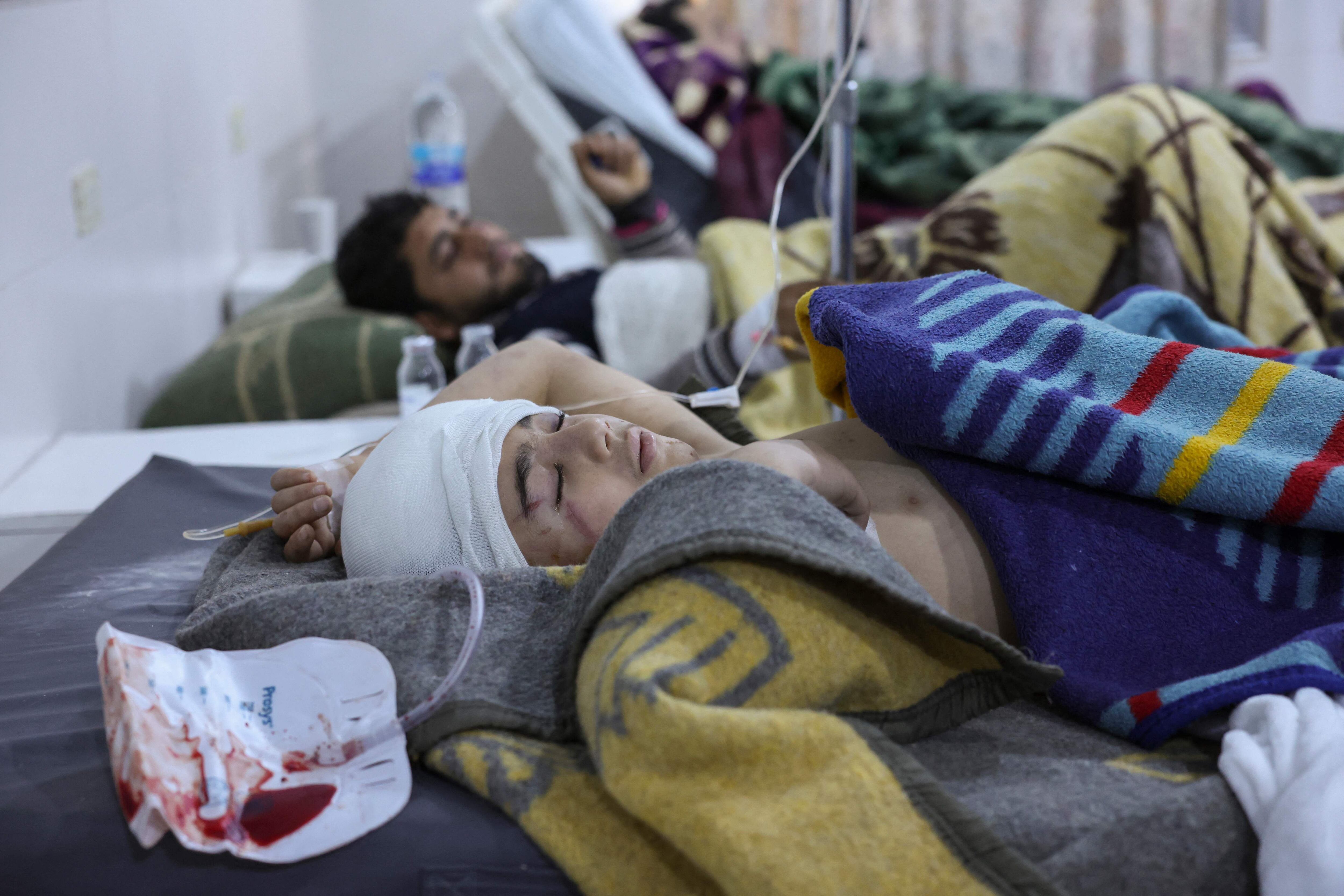 People injured in a morning earthquake receive treatment at al-Rahma hospital in Syria's  town of Darkush, on the outskirts of the rebel-held northwestern province of Idlib, on February 6, 2023. - A 7.8-magnitude earthquake hit Turkey and Syria on February 6, killing hundreds of people as they slept, levelling buildings, and sending tremors that were felt as far away as the island of Cyprus and Egypt. (Photo by OMAR HAJ KADOUR / AFP)