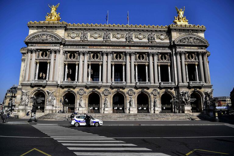 Un coche de la policía francesa, este jueves, ante la fachada desierta de la Ópera de París.