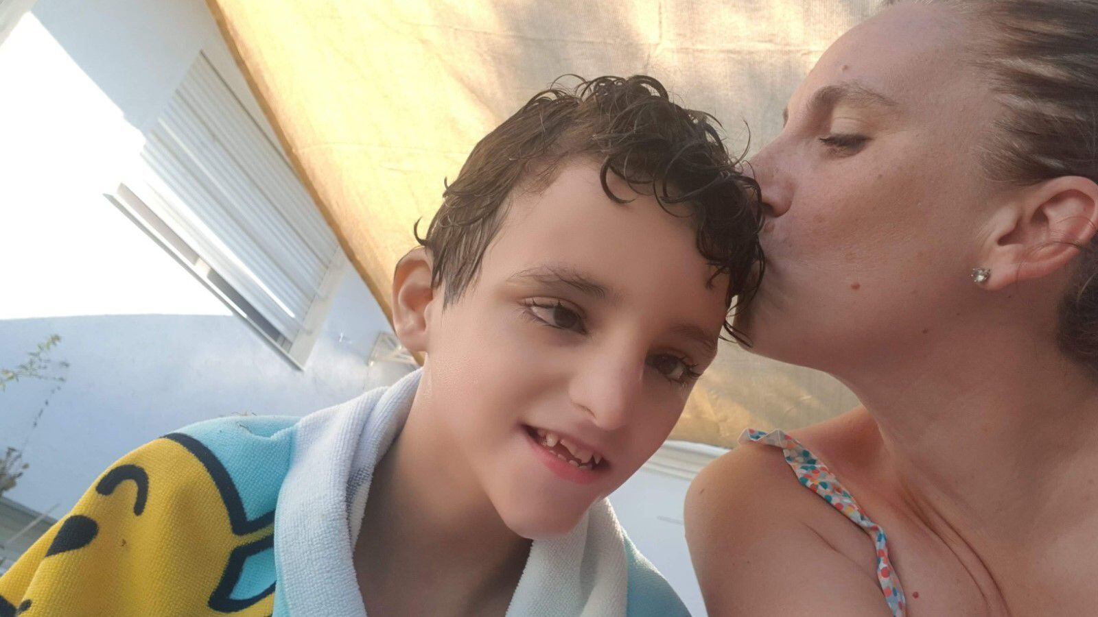 Vanesa Pérez besa a su hijo Rodrigo, adolescente que sufre autismo severo.