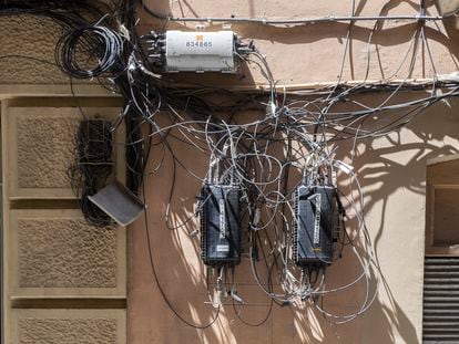 Cajas y cables de compañías de telecomunicaciones sobre una fachada, esta semana en Barcelona.