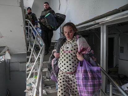 An injured pregnant woman walks downstairs in a maternity hospital damaged by shelling in Mariupol, Ukraine, Wednesday, March 9, 2022. (AP Photo/Evgeniy Maloletka)