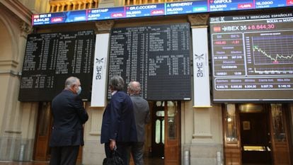 Tres hombres observan la evolución de las cotizaciones en el Palacio de la Bolsa, en Madrid, el pasado 13 de mayo.