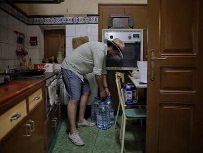 El hijo de un vecino de L'Albi (Lleida) sube garrafas de agua a su casa, en junio pasado, durante un episodio de contaminación del agua potable.
