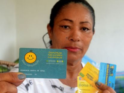 Ermanda Maria de Sena, la primera usuaria registrada en Bolsa Familia, muestra su carné en enero de 2020 en su casa, en el interior de Alagoas.