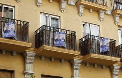 Anuncios de venta de viviendas en los balcones de un edificio de una calle de Madrid.