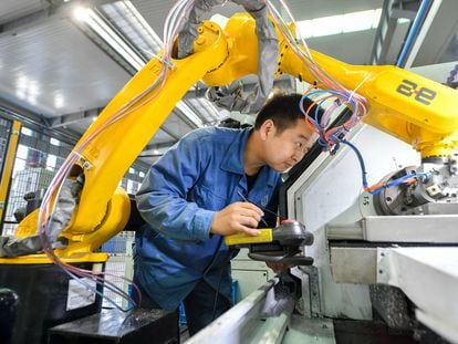 Un técnico trabaja con robots en una fábrica inteligente de Zhejiang, China, en octubre de 2020.