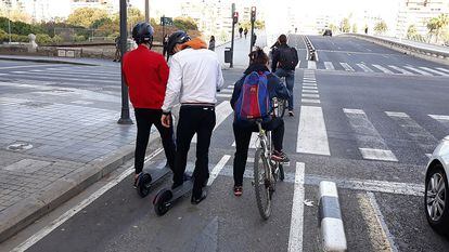 Varios usuarios de bicicletas y patinetes circulan por un carril bici en Valencia.