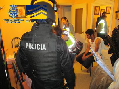 La policía en uno de los registros con uno de los 28 detenidos por tráfico de menores.