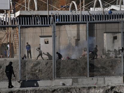 Varios ciudadanos marroquíes lanzan piedras en la frontera del Tarajal, en Ceuta, este miércoles.