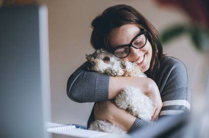 Una mujer abraza a su mascota.