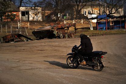 Un hombre con una moto atraviesa la casi desierta población de Petropavlivka.