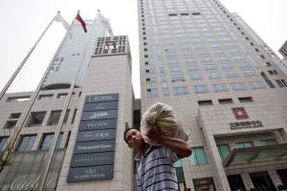 Un hombre camina con una bolsa en una zona comercial de Pekín, China. EFE/Archivo