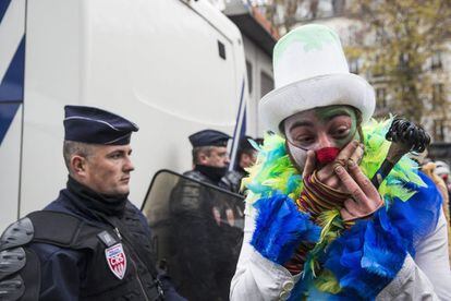 Un hombre vestido de payaso se burlan de la policía francesa durante una protesta.