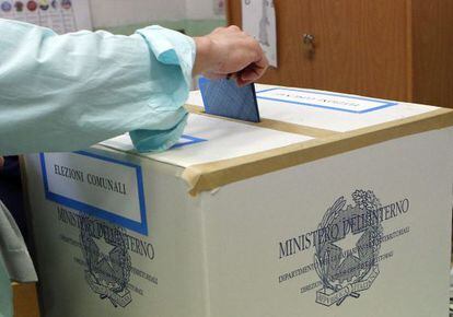 Un hombre deposita su voto en el centro electoral de Cvitavecchia, a 70 kil&oacute;metros al norte de Roma ayer en las municipales italianas.
 