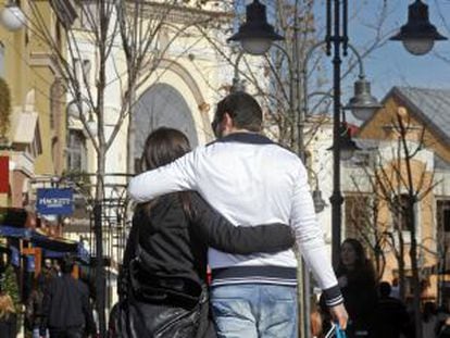 Una pareja en la entrada de centro comercial Las Rozas Village.