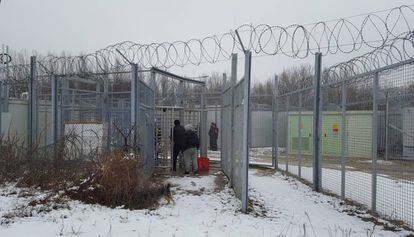 Haj y Musafir en uno de los controles de la frontera de Serbia con Hungría, tras la valla, los contenedores que las autoridades húngaras han convertido en viviendas.