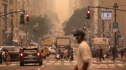 A man wears a mask in a haze-filled sky of Manhattan, New York.