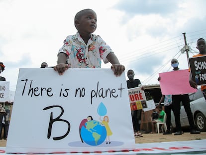 Un niño y otros jóvenes activistas  ugandeses contra el cambio climático se manifiestan en el barrio de Luzira de Kampala, Uganda, el 25 de septiembre de 2020.