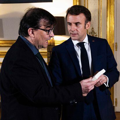 Macron le enseña un libro de su despacho a Cercas, el lunes en el palacio del Elíseo.