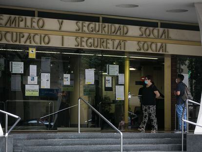 Varias personas esperan en las puertas de la oficina de Empleo y Seguridad Social de Barcelona.