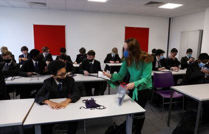 A teacher hands out masks in an educational center, last March in London.