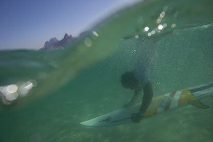 Magno Neves se sumerge con su tabla en la playa de Arpoador, en Río de Janeiro (Brasil).