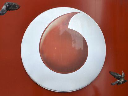 Palomas sobrevuelan el logo de Vodafone en Londres.