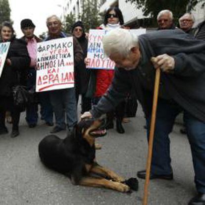 Un pensionista acaricia a un perro en una protesta hoy en Atenas contra las medidas de austeridad aprobadas por el Parlamento.