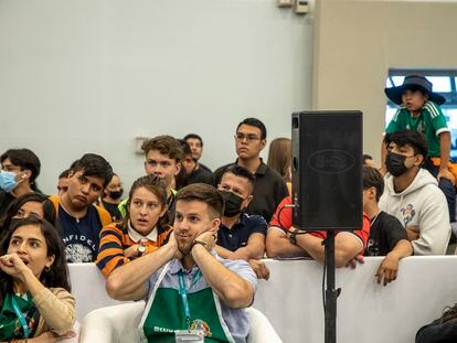Asistentes a la FIL observan el partido México vs Argentina en los pasillos de la Feria.
