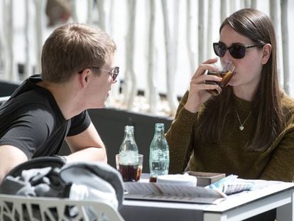 Dos joves prenen uns refrescos en una terrassa a Barcelona.