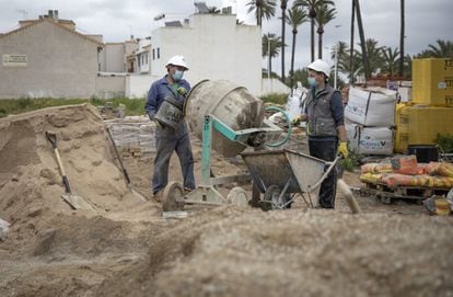 Obreros trabajando en la construcción de viviendas en Valencia.