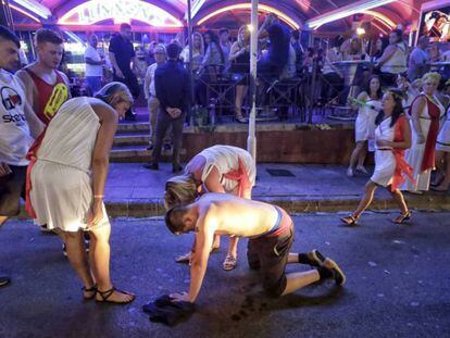 Un turista en estado de embriaguez se desploma en una calle de Magaluf. En vídeo, el Gobierno de Islas baleares aprueba una ley para la lucha total contra el turismo de borrachera.