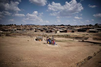 Tres niños sacan agua de un pozo en Dzaleka. Los vecinos se quejan de que no hay suficientes puntos de recogida y acceso.