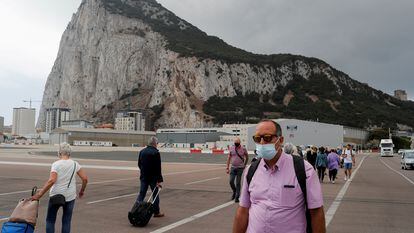 Varias personas cruzan a pie la pista del aeropuerto de Gibraltar, a la entrada de la colonia.