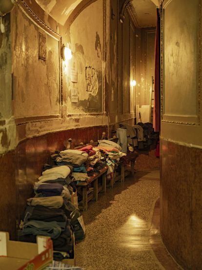 Pilas de ropa amontonadas en un pasillo del teatro Kurbas, en la ciudad de Lviv (Ucrania), que se convirtió en centro de acogida al inicio de la invasión rusa.