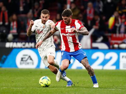 Rodrigo de Paul ante Dani Rodríguez, en el partido del Atlético ante el Mallorca en el Wanda Metropolitano.