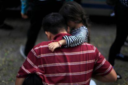 Una ni&ntilde;a abraza a su padre tras ser deportados de M&eacute;xico a San Salvador.