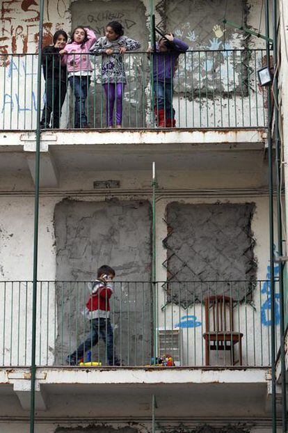 A Vecinos pasean por los muros tapiados del edificio de Vallecas del que les van a desahuciar.